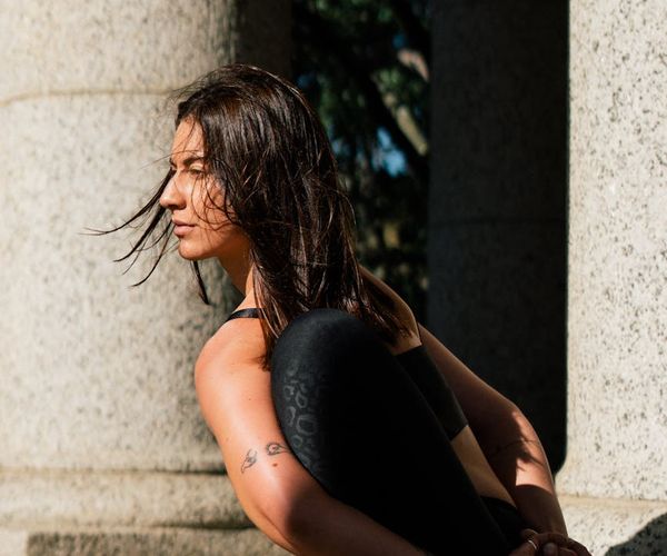 A person sitting cross-legged, meditating peacefully outdoors.